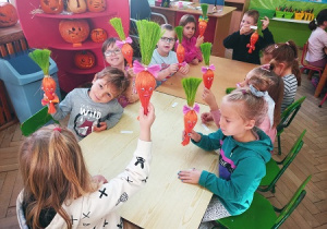Dzieci tworzą sizalowe marchewki.