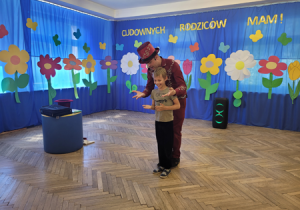 Magik z chłopcem pokazuje sztuczkę ze znikającą chusteczką.