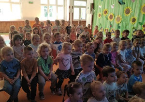 Dzieci z zaciekawieniem czekają na występ magika.