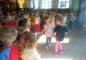 Dziewczynki tańczą w parze na parkiecie.
