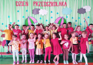 Dzieci pozują pod napisem "Dzień Przedszkolaka"