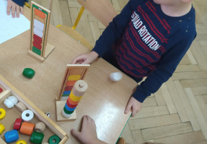 Dzieci budują wieżę z klocków według wzoru