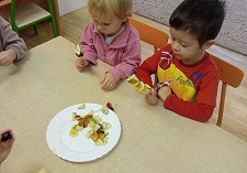 Dzieci nakładają owoce na wykałaczki.