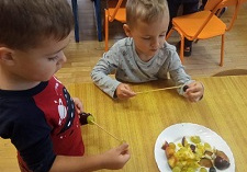 Dzieci nakładają owoce na wykałaczki.