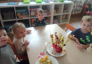 Dzieci prezentują owocowe szaszłyki.