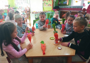 Dzieci tworzą sizalowe marchewki.