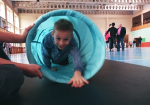 Chłopiec pokonujący gimnastyczny tunel