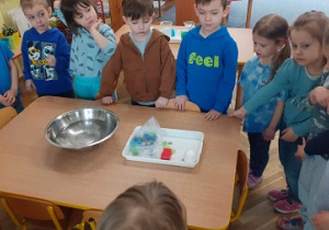 Dzieci biorą udział w zabawach badawczych z wodą.