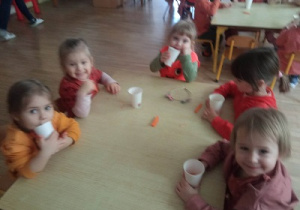 Dzieci piją sok z marchwi.