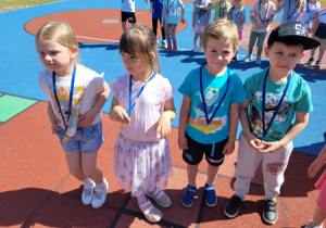 Dzieci prezentują zdobyte medale.