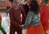Dzieci tańczą w parze podczas balu.