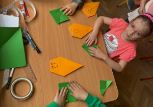 Dzieci wykonują marchewkę techniką origami.