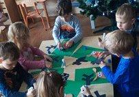 Dzieci wykonują kartkę świąteczną według instrukcji obrazkowej.