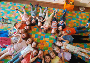 Dzieci leżą na nowym dywanie.