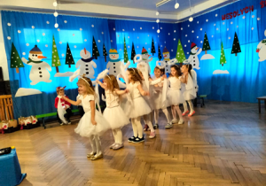 Dziewczynki przebrane za aniołki wykonują świąteczny taniec.