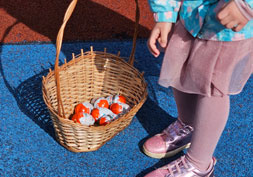 Dziecko szuka ukrytych jajek wielkanocnych w ogrodzie przedszkolnym.