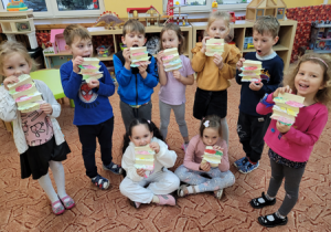 Dzieci pozują z wykonanymi przez siebie papierowymi kanapkami.
