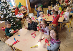 Dzieci podczas warsztatów wykonują Mikołaje z sizalu.