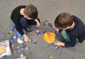 Chłopcy układają puzzle - Układ Słoneczny