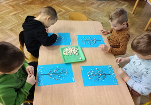 Dzieci tworzą prace plastyczną "Cztery pory roku".