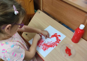 Dziewczynka maluje godło Polski.