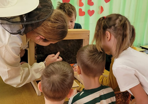 Dzieci biorą udział w warsztatach pszczelarskich