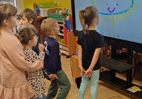 Dzieci korzystają z monitora multimedialnego.