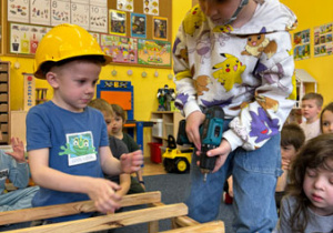Dzieci podczas warsztatów budują konstrukcję domku.