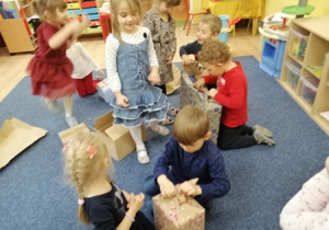 Dzieci rozpokowują prezenty od Świętego Mikołaja