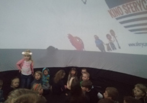 Dzieci oglądają film edukacyjny o kosmosie podczas seansu w kinie sferycznym